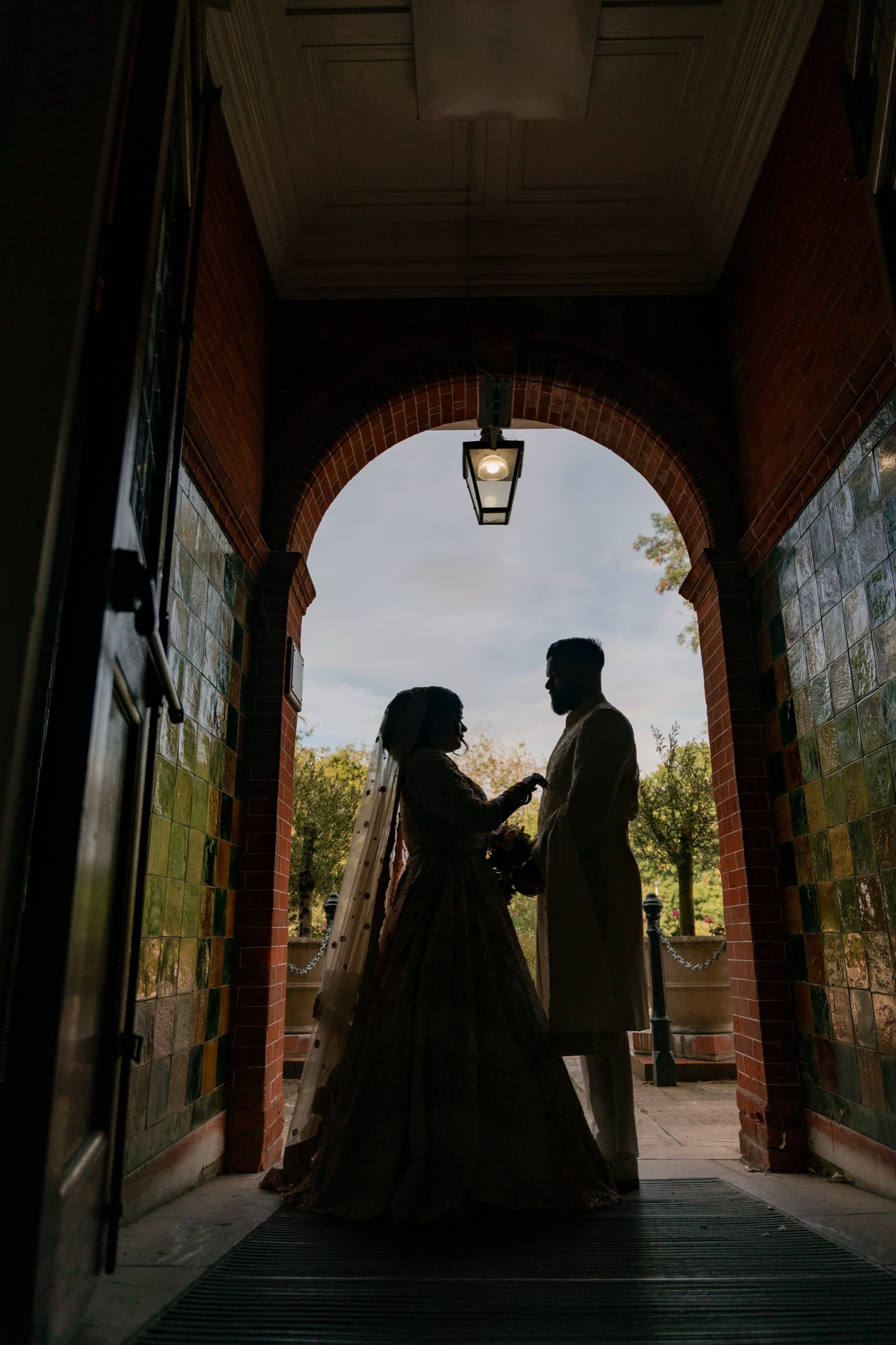 A wedding couple by Chigwell Hall's iron gates
